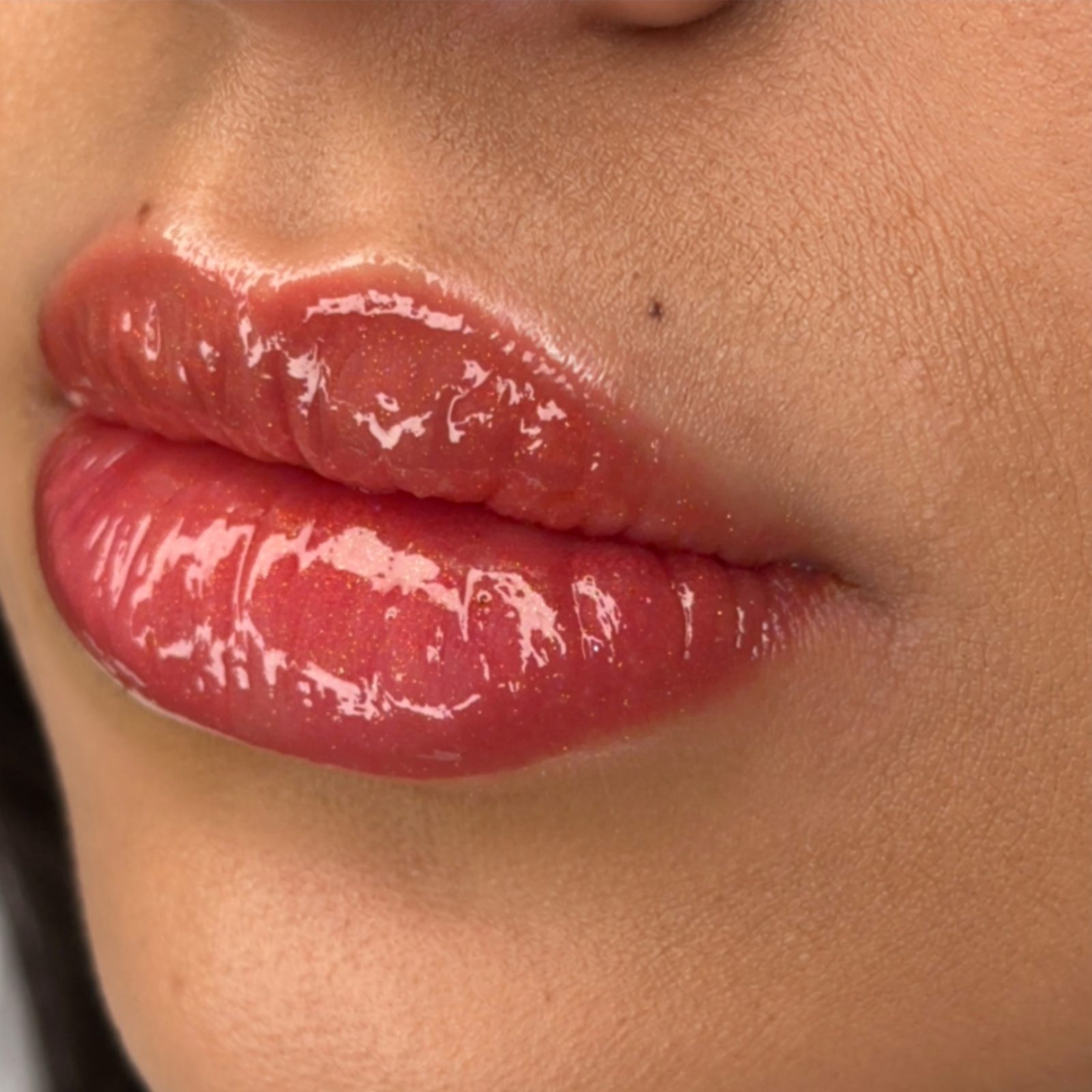 Close-up of healed-looking super natural lip blush in a soft rosy red with glossy finish