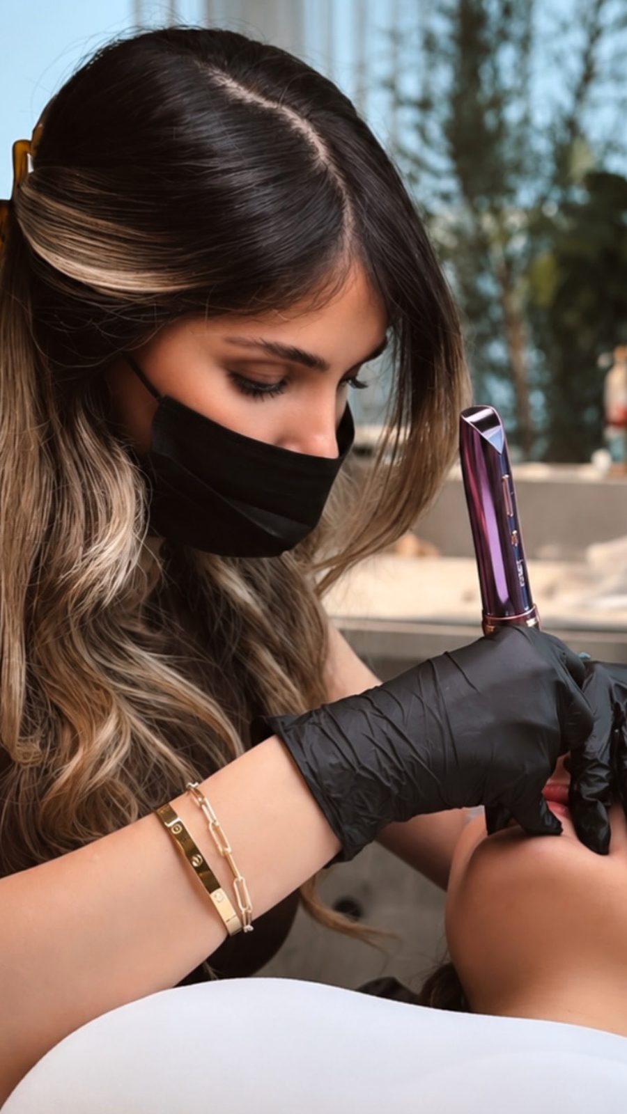 Yalora artist at work, holding a PMU pen during a lip treatment