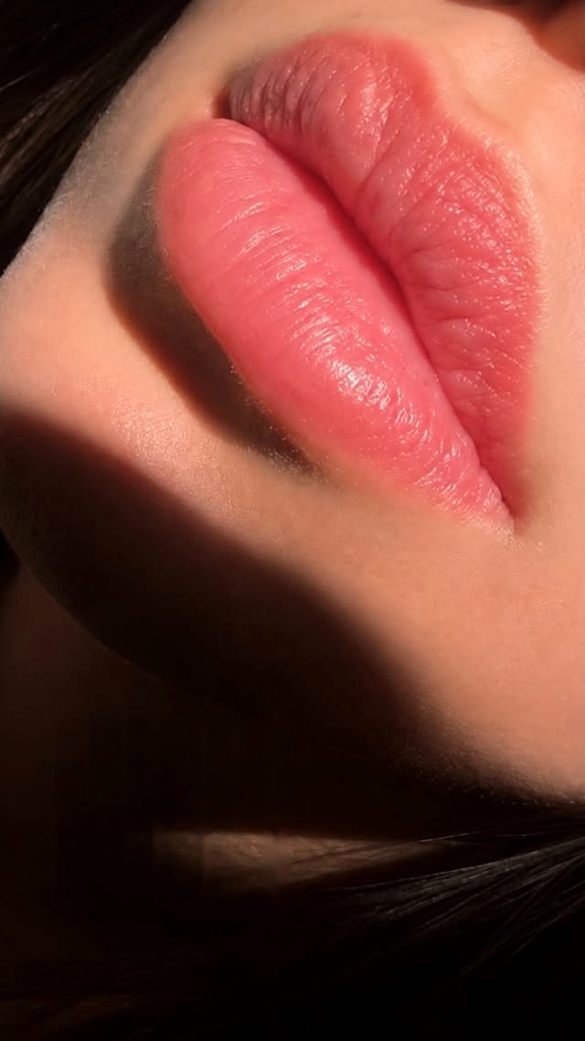 Close-up of healed lip blush after the touch-up session, soft natural pink lips in warm light and shadow